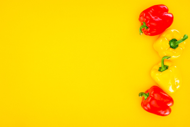 top view of fresh raw organic peppers isolated on yellow - Foto, imagen
