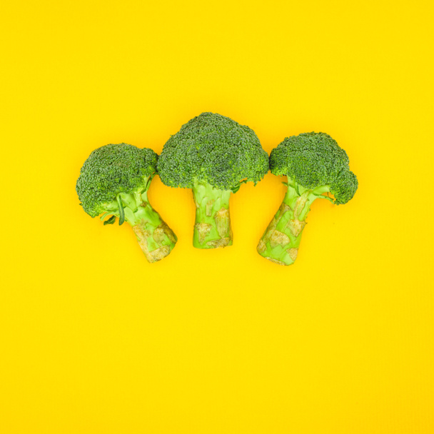 top view of fresh green organic broccoli isolated on yellow - Zdjęcie, obraz