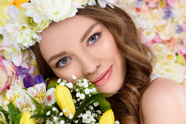 retrato de cerca de la joven feliz con corona floral y ramo de flores
 - Foto, Imagen