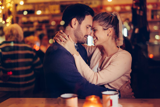 Romantic young couple dating in pub at night - Foto, imagen