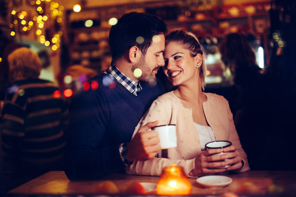 Romantic young couple dating in pub at night - Photo, Image