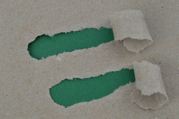 Bastelpapier an zwei Stellen aufgerissen, darunter leeres dunkelgrünes Papier mit Platz für eine Botschaft - Foto, Bild