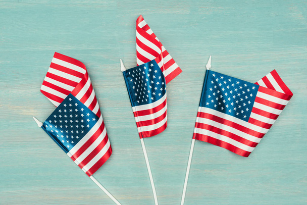 vista superior de las banderas americanas dispuestas en la superficie azul de madera, concepto de día de presidentes
 - Foto, imagen