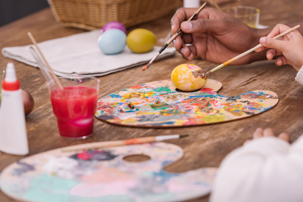 cropped image of african american father and daughter painting easter eggs - Φωτογραφία, εικόνα