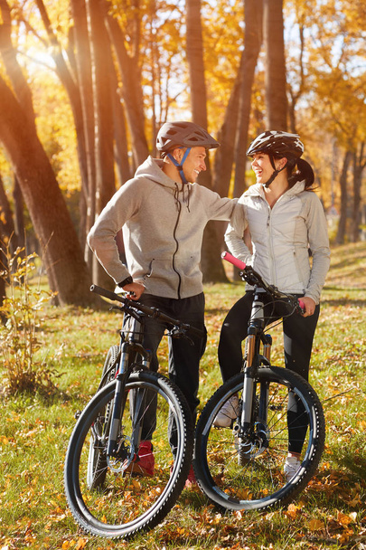 backlight photo of a couple having fun by bike - Photo, Image