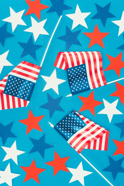 top view of arranged stars and american flags isolated on blue, presidents day celebration concept - 写真・画像