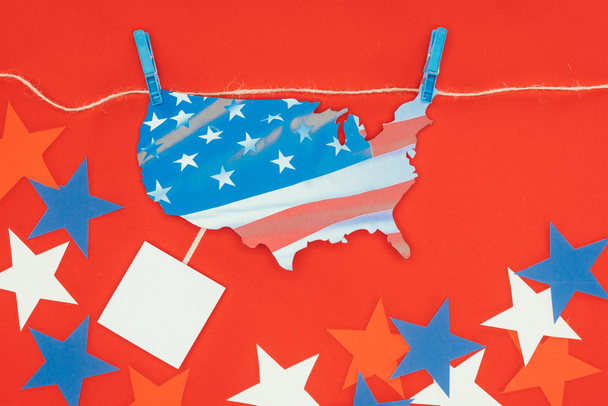 vista superior del pedazo de mapa con la bandera americana colgando en la cuerda y las estrellas aisladas en rojo
 - Foto, imagen