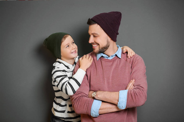 Stylish father and son on gray background - Фото, изображение