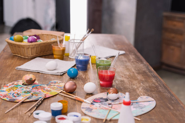 festett tojások festékek és ecsetek, a fából készült asztal, húsvéti koncepció - Fotó, kép