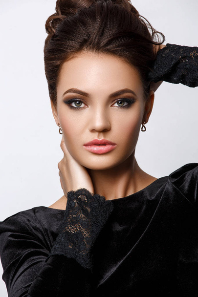 Studioporträt einer schönen, attraktiven jungen Frau mit smartem Abend-Make-up und Frisur, weißem Hintergrund, Kosmetik und Schönheit - Foto, Bild