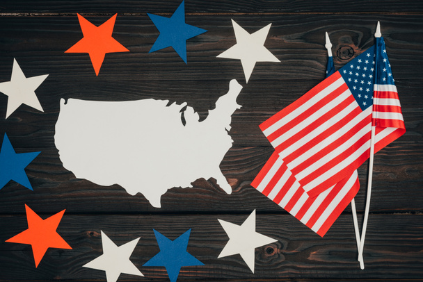 vista superior de las banderas americanas dispuestas, pedazo de mapa hecho de papel y estrellas en la superficie de madera, concepto de celebración del día de los presidentes
 - Foto, imagen