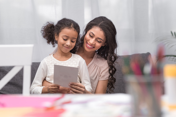 african american mother and daughter looking at greeting card on mothers day - Photo, Image