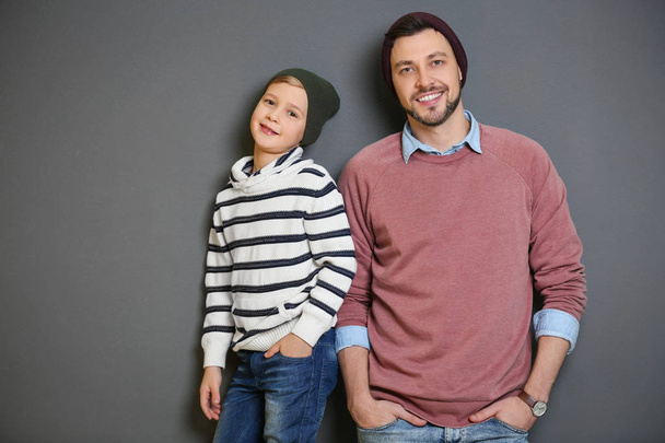 Stylish father and son on gray background - Foto, Imagen