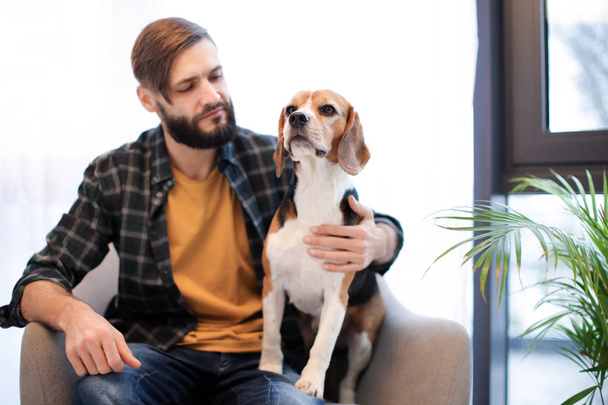 Handsome young hipster with dog at home - Foto, Imagem