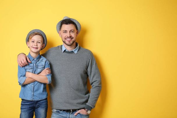 Stylish father and son on color background - Foto, Imagem