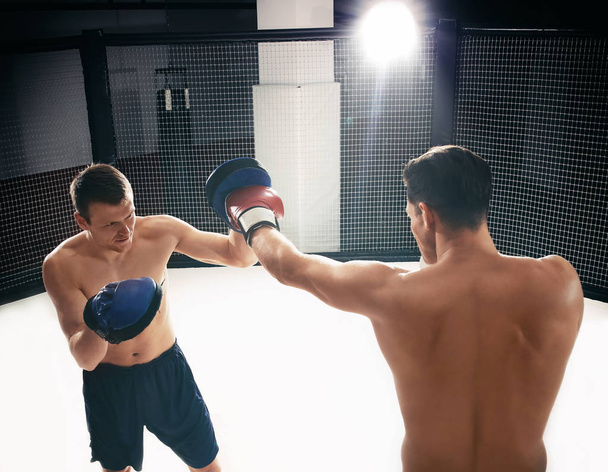 Young boxer training in gym with personal coach - Fotoğraf, Görsel