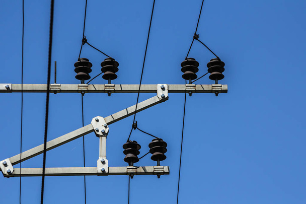 Електричні дроти з ізоляторами розтягуються зверху на небі
 - Фото, зображення