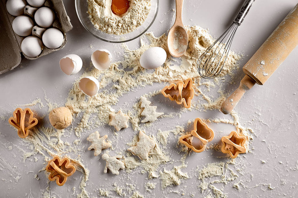 Concept de cuisson : pâte crue pour biscuit, œufs, farine, découpeuses en forme d'étoile et papillon sur une table blanche. Vue du dessus
. - Photo, image