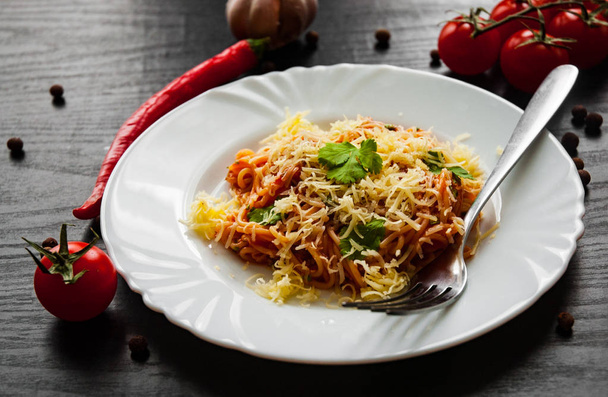 Pasta Spaghetti with tomato sauce and grated cheese on a dark wooden background - Valokuva, kuva