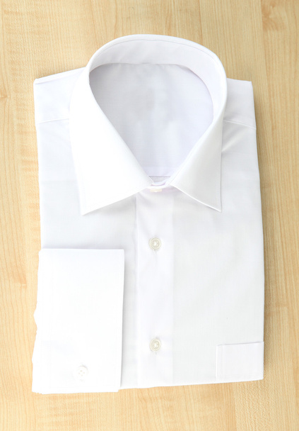 New white man's shirt on wooden background - Foto, afbeelding