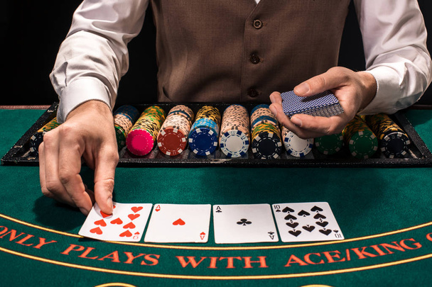 Close up de revendedor holdem com cartas de baralho e fichas na mesa verde
 - Foto, Imagem