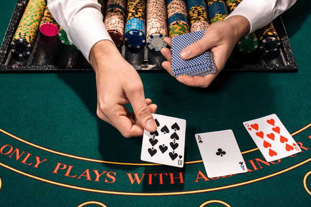 Nahaufnahme des Holdem Dealers mit Spielkarten und Chips auf grünem Tisch - Foto, Bild