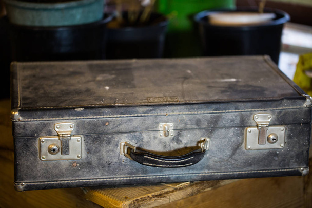 Чемодан, старый пыльный чемодан в мастерской
 - Фото, изображение