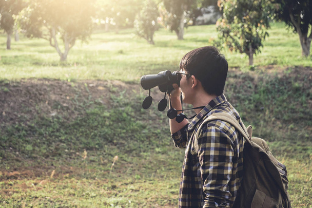 Young Man backpacking travel are using binoculars - 写真・画像