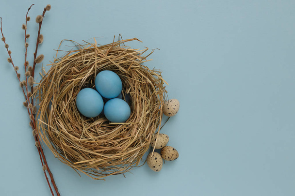 Su uno sfondo blu si trovano tre uova di Pasqua di colore blu in un de
 - Foto, immagini