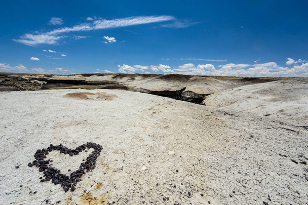 coração feito de seixos de pedra em uma paisagem seca do deserto
 - Foto, Imagem