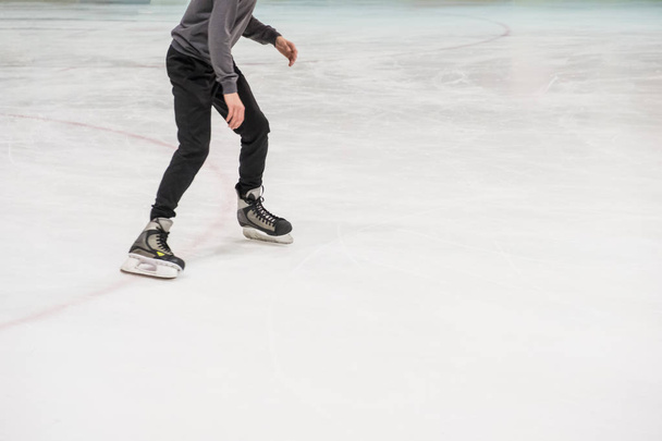 cropped shot of skates ice skating on rink - Photo, image