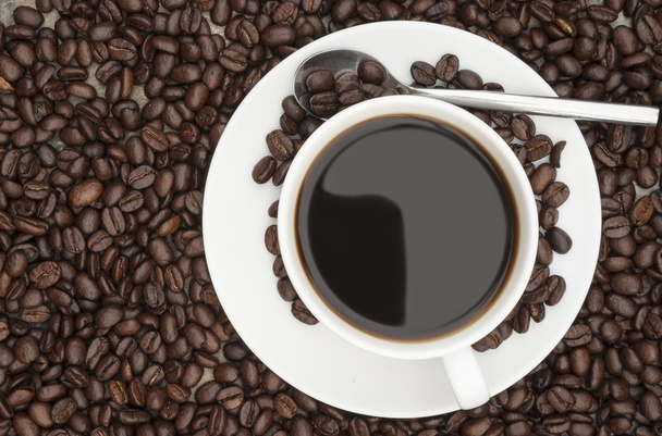 dampfend heißen Kaffee umgeben von dunklen Kaffeebohnen mit - Foto, Bild