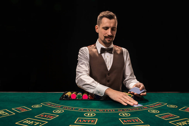 Croupier achter de tafel in een casino gokken. - Foto, afbeelding