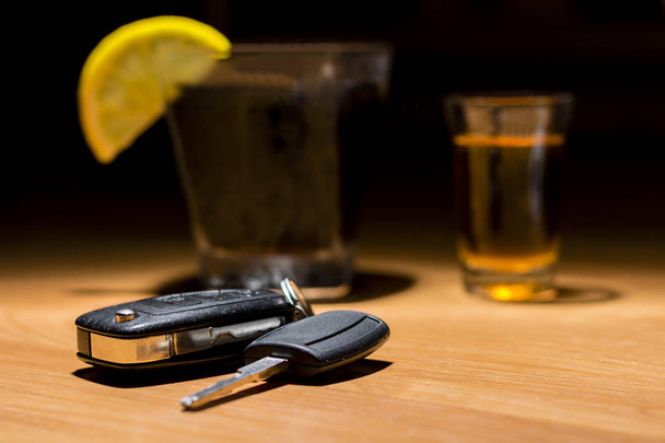 Llaves de coche colocadas en el bar junto a cóctel y whisky
 - Foto, imagen