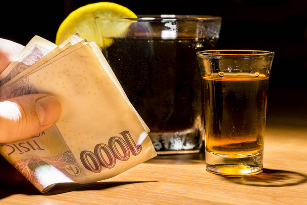 La mano de un hombre sosteniendo billetes en un bar
 - Foto, imagen