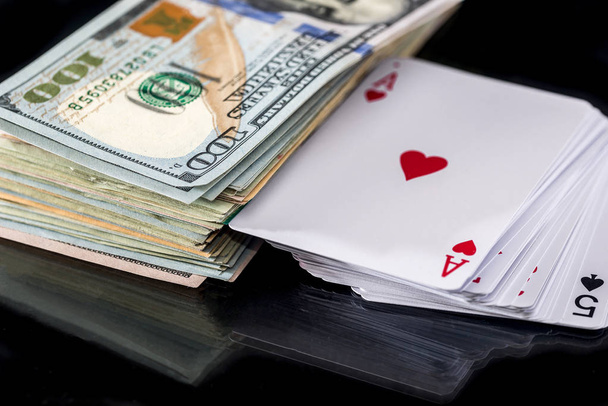 four poker aces with dollar isolated on black. - 写真・画像