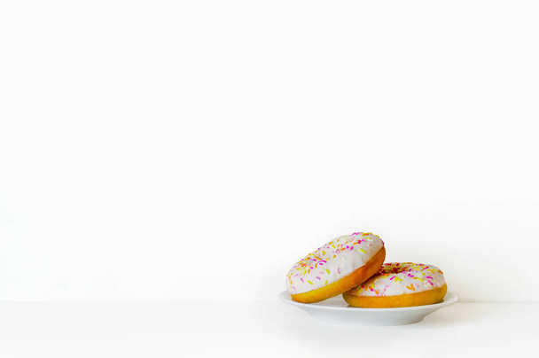 Donut on a plate on a white background. Minimalism. Side view. - Fotó, kép