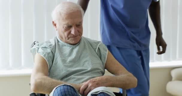 4K Caring medical worker speaking words of comfort to elderly man in wheelchair - Imágenes, Vídeo