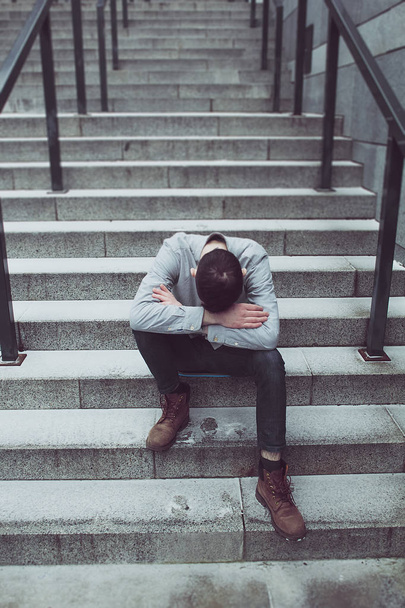 L'uomo disperato, depresso piegò la testa, seduto sui gradini
. - Foto, immagini