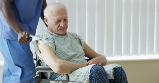 4K Caring medical worker speaking words of comfort to elderly man in wheelchair - Imágenes, Vídeo