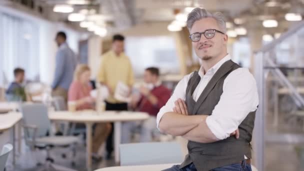 4K Retrato del gerente de negocios sonriente en la oficina con el personal trabajando en segundo plano
 - Imágenes, Vídeo