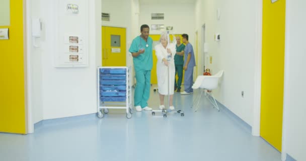 4 k pečující zdravotní pracovník pomáhá starší pacientka v rušných nemocničních - Záběry, video