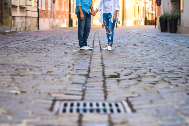 a guy and a girl are on an old cobblestone street in Europe - Foto, Imagen