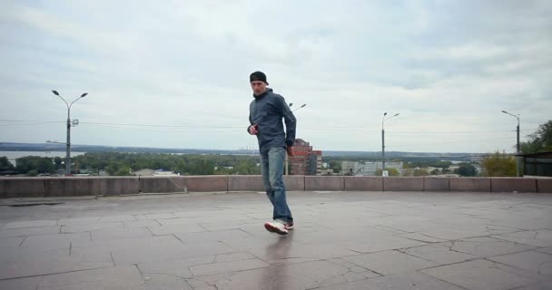 művészet, tánc, életmód, emberek, 4 k koncepció - breakdancerről az utcán. Aktív fiatal férfi tánc break dance, hip-hop stílus a város. - Felvétel, videó