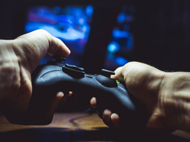 close up of person holding gamepad and playing games	 - Photo, Image