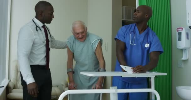 4K Caring medical workers in hospital assisting elderly man in a private room - Záběry, video
