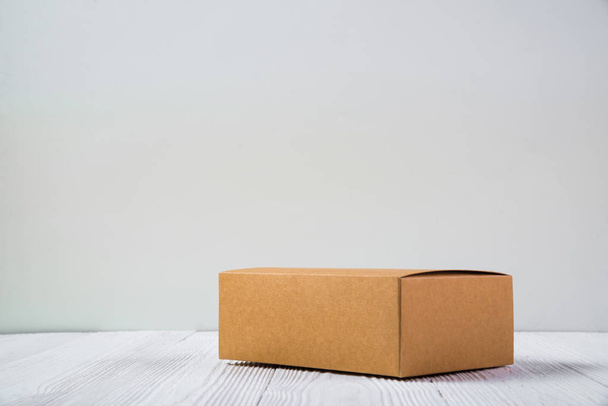 Empty Package brown cardboard box or tray on bright wooden table - Foto, afbeelding