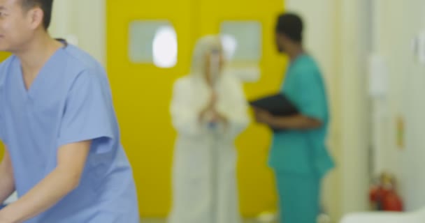 4K Hymyilevän miespuolisen lääkärin muotokuva kiireisessä modernissa sairaalassa
 - Materiaali, video