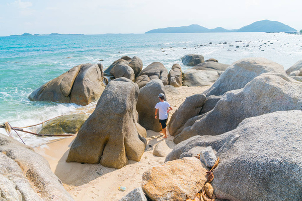 Gyermek- és fuss játék nagy sziklák között a trópusi partján én - Fotó, kép