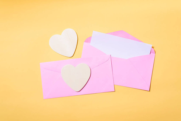Sobre rosa con tarjeta blanca en blanco en el interior y corazones
  - Foto, Imagen